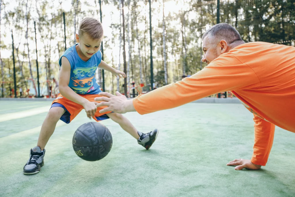 Papa et enfant qui jouent au basketball.